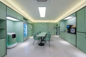 A conference room with a table and chairs, a vending machine, and a refrigerator. - Hi Inn (Beijing Tiantan East Gate) (Beijing)