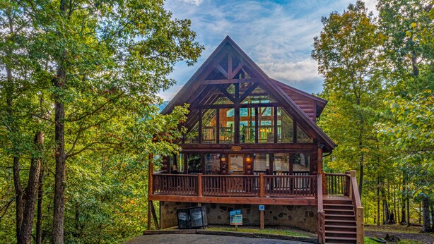 Un chalet avec une façade en bois, un balcon et des fondations en pierre.