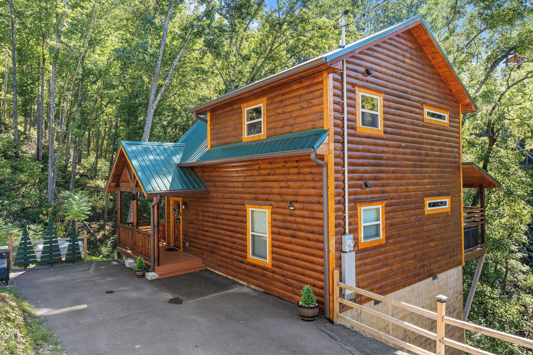 Une cabane en rondins dotée d’un porche, d’un hall d’entrée couvert et d’une petite terrasse.