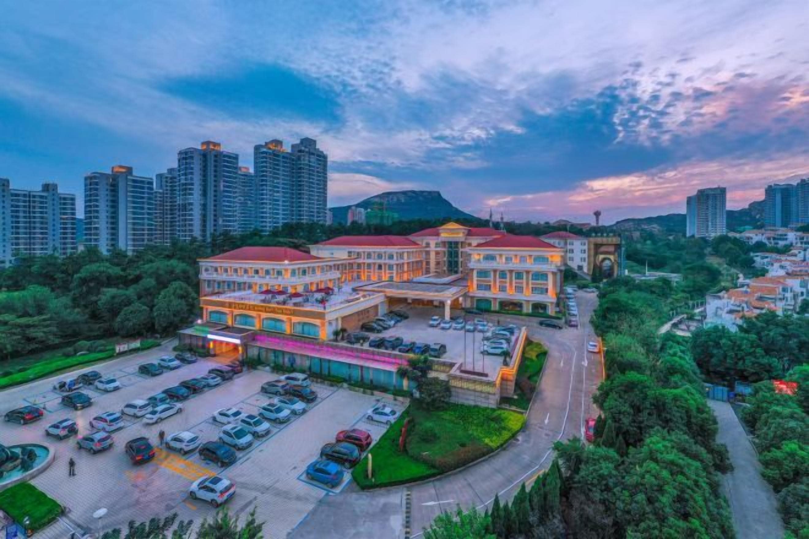A hotel with multiple buildings, a parking lot, and a surrounding urban area.