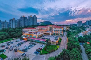 Un hotel con varias edificaciones, estacionamiento y zonas urbanas circundantes.