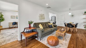 Una sala de estar moderna con sofá, mesa de centro y comedor.