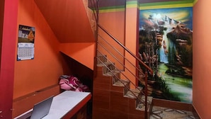 A staircase with a metal railing leading to a lower level. A calendar is visible on the wall to the left. - Nexus Mirasol Backpackers (Copacabana)