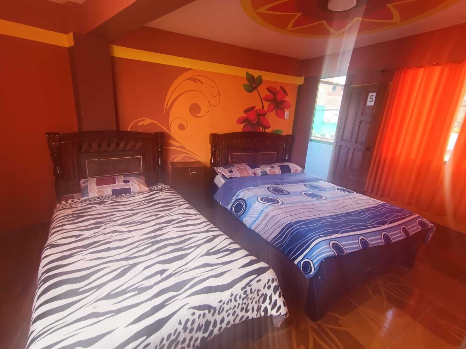 Una habitación con dos camas, cada una con una colcha de diseño diferente.