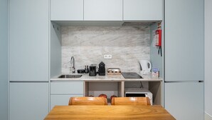 A compact kitchen with a marble backsplash, a coffee machine, a kettle, and a toaster. - GuestReady - Lovely heaven in Porto (Porto)
