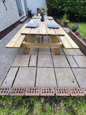 Enjoy al fresco dining at this outdoor patio with a picnic table and comfortable seating for all.
