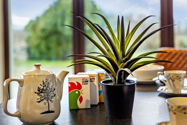 Une table avec une théière, une plante en pot et quelques boîtes.