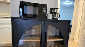 A dark wooden cabinet with glass doors and a microwave on top. - Large parking lot/sleeps 8 (Laredo)