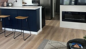 Una cuina moderna amb una illa integrada, microones, nevera i televisió.