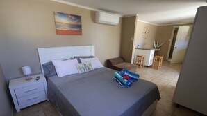 A bedroom with a bed, bedside table, and a desk area with chairs. - Chic 1-bedroom apartment with WiFi, AC in phenomenal Tankilendert (Tankilendert)