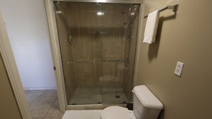 A bathroom with a glass-enclosed shower, a toilet, and a towel rack. - Chic 1-bedroom apartment with WiFi, AC in phenomenal Tankilendert (Tankilendert)