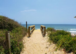 A wooden pathway leading to a beach with a wooden railing on both sides. - Back A Bit by Topsail Realty (Holly Ridge)