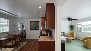 A modern kitchen with wooden cabinets, a granite countertop, and a dining area with a wooden table and chairs. - Clean, Bright & Private WHOLE HOUSE 4 YOU. Safe, Centrally Located, Garage (New Britain)