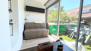A modern living room with a sofa, a table with decorative items, and a view of the outside.