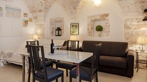 Ein gemütlicher Essbereich mit Tisch, Stühlen und einer Couch.