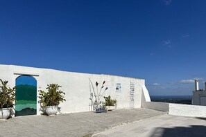 Un edificio blanco con una puerta azul y plantas en macetas.
