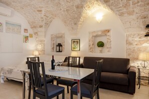 Un rincón comedor acogedor con una mesa, sillas y un sofá.