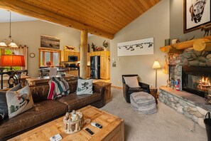 A cozy living room with a fireplace, wooden furniture, and a stone fireplace surround.