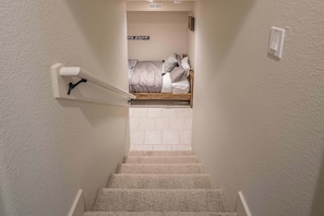Eine Treppe führt zu einem Schlafzimmer mit einem Bett und einem Schild darüber.