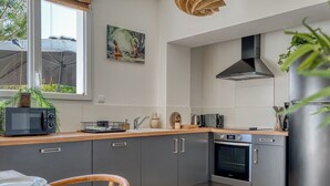 A modern kitchen with grey cabinets, a microwave, a toaster, and a stainless steel refrigerator. - Villa Indonésie - Domaine Le Sherwood (Notre-Dame-de-Monts)
