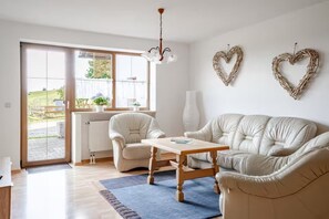 A living room with a sofa set, a coffee table, and a chandelier. - Spacious ground-floor apartment for the whole family near Buchenberg in the Allgäu region (Buchenberg)