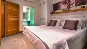 Une chambre à coucher avec un grand lit, une armoire en bois et une étagère fixée au mur.