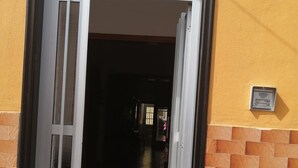 A hotel entrance with a large glass door, a number '25' sign above, and a 'W' sign on the wall.