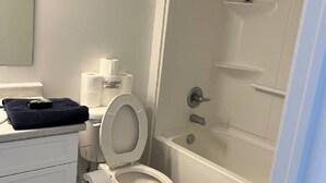 Un baño con inodoro, bañera y ducha.