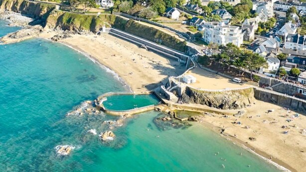 An aerial view of a coastal area with a beach, rocky shoreline, and a small pool. - La Royale Jacuzzi Sauna Jardin Gare - Hôtel Lefort (Guingamp)