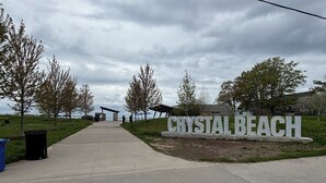 A pathway leading to a sign that reads "CRYSTAL BEACH".