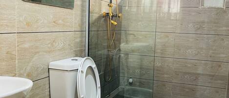 A bathroom with a toilet, sink, and shower.