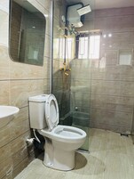 Un baño con inodoro, lavabo y ducha.