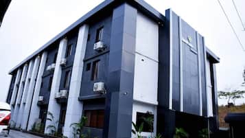 Un edificio moderno con techo plano, múltiples unidades de aire acondicionado y un diseño limpio y minimalista.