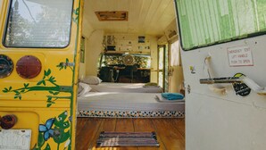 A compact, well-lit interior with a bed, a small table, and a fan. - Chilamate Rainforest Beach Retreat (Nosara)
