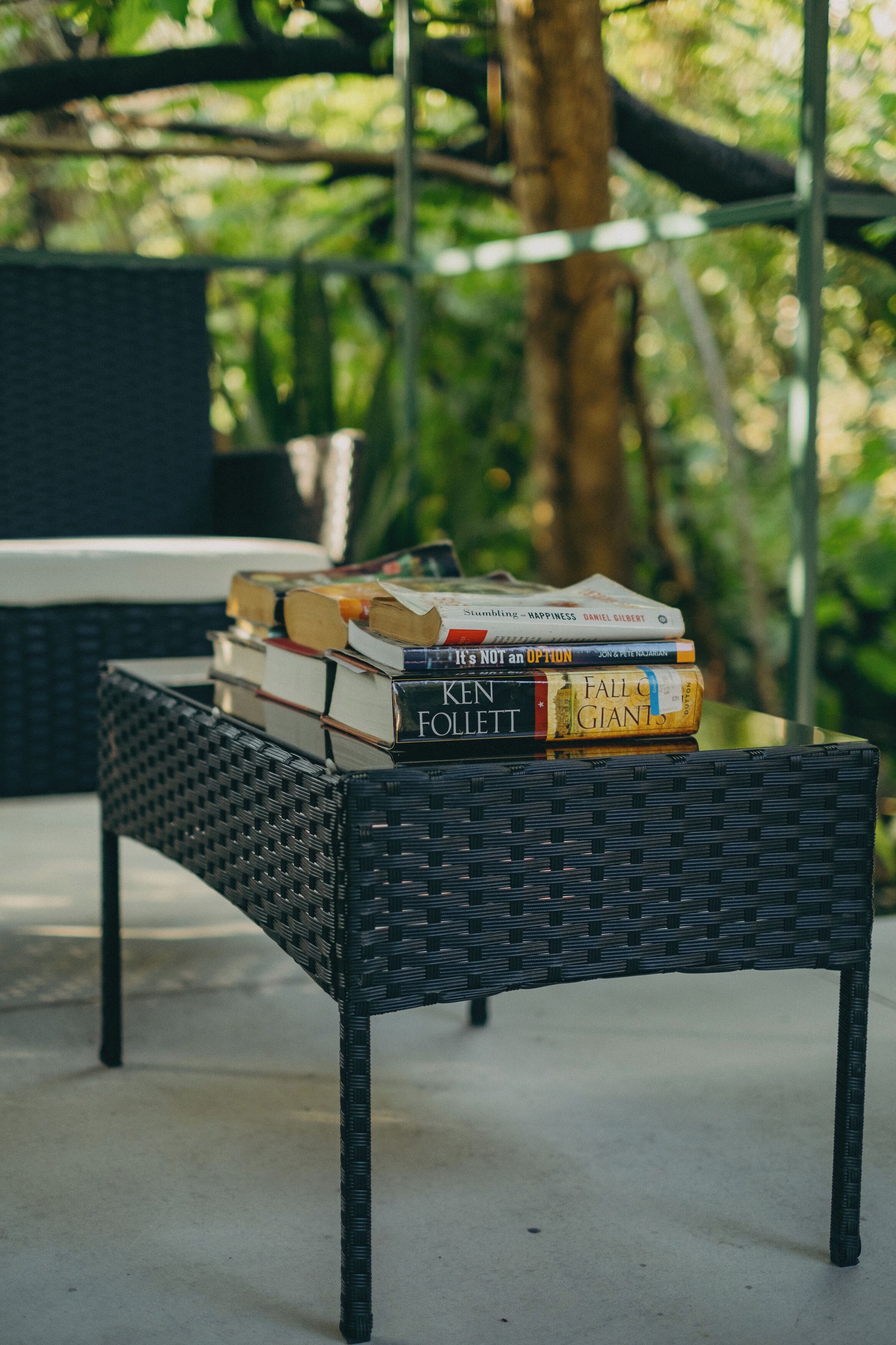 Une table en osier sur laquelle est posée une pile de livres.