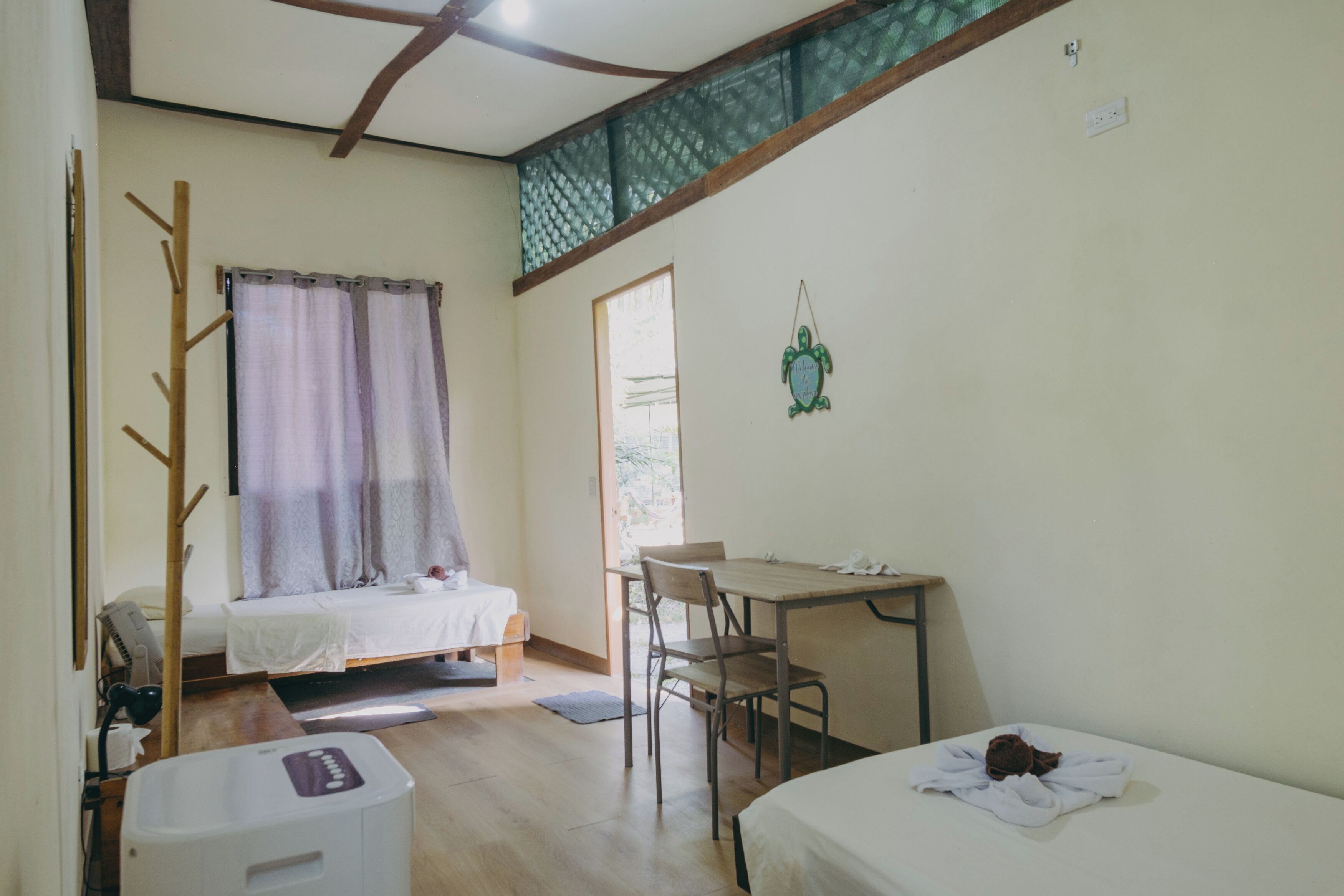 A room with a bed, a desk, a chair, a heater, and a window with curtains.