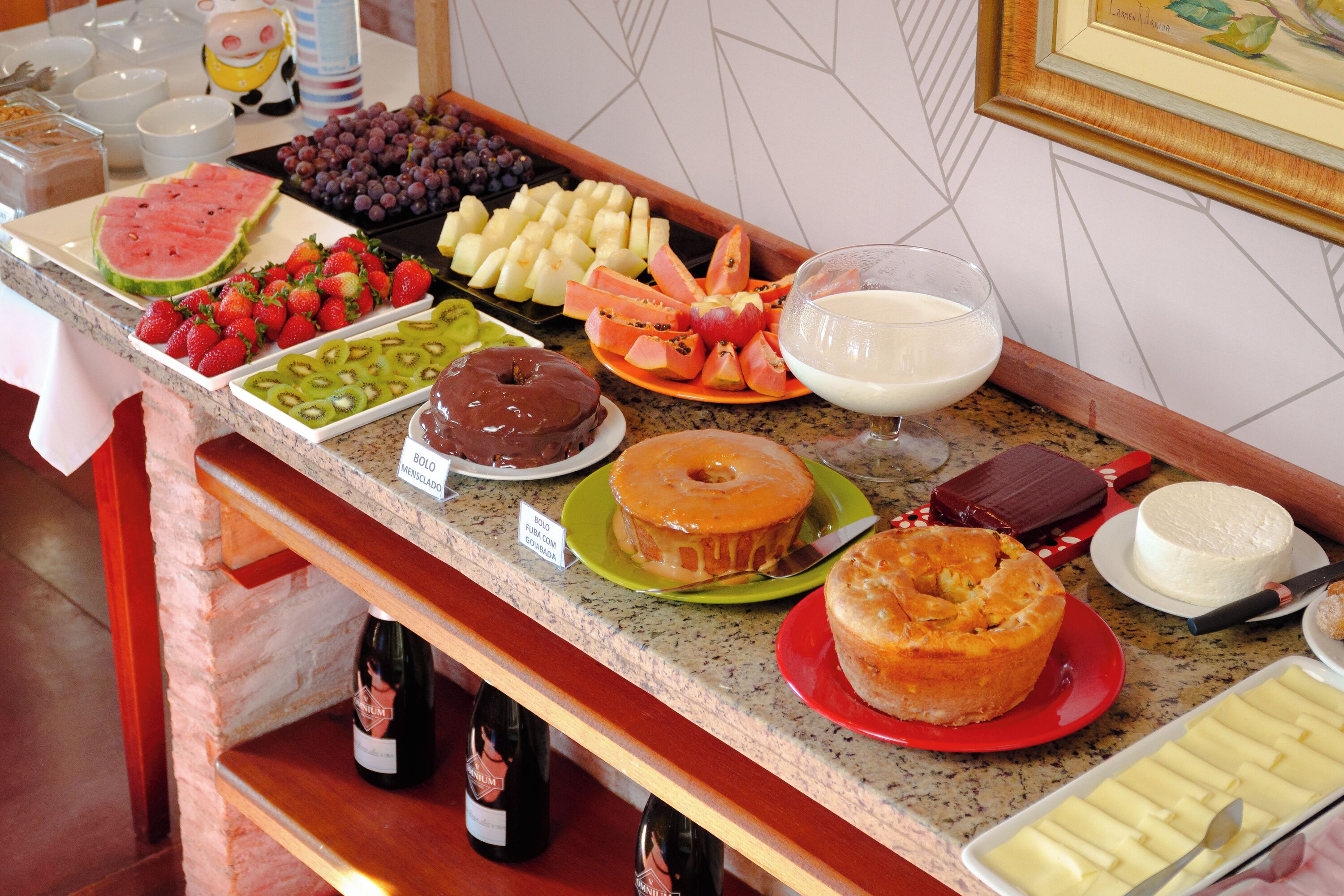 A buffet with various food items and a selection of wine bottles.