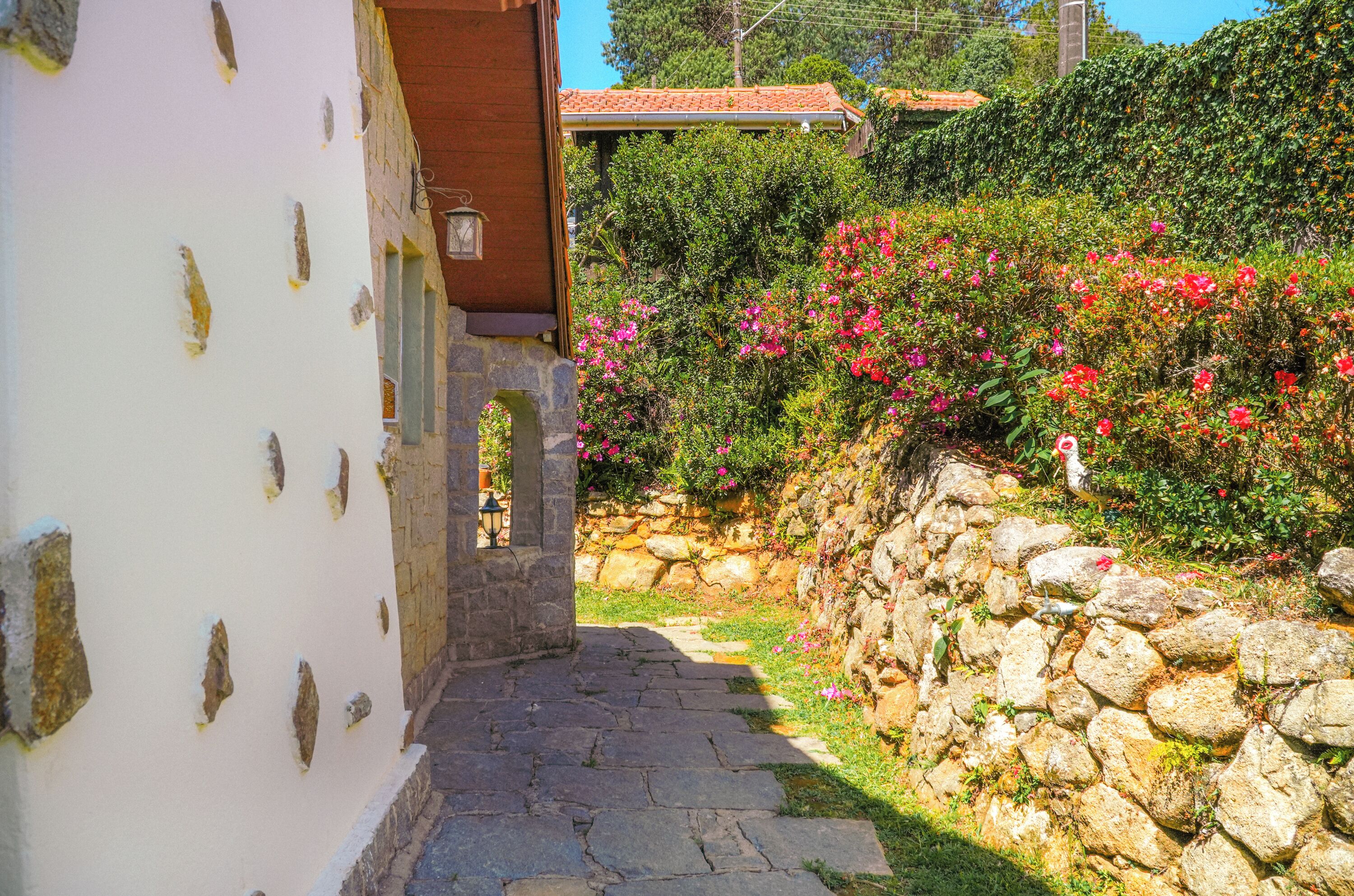 Un camino de piedra que lleva a un edificio con fachada blanca y detalles de piedra.