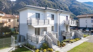 A two-story building with a balcony and a staircase leading to the upper floor. - Villa Sunshine - Luxury property with large garden and Pool, near the lake, parking e-charge, ideal for people with mobility issues (Dervio)