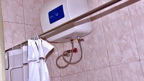 A bathroom with a white shower enclosure, a handheld showerhead, and a wall-mounted control panel. - Cozy Studio Near UN Base | 5-Min Drive to Entebbe Airport (Entebbe)