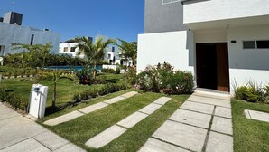 A modern two-story house with a concrete pathway leading to the entrance. - Residencia Altavela Privada 51 (Valle de Banderas)