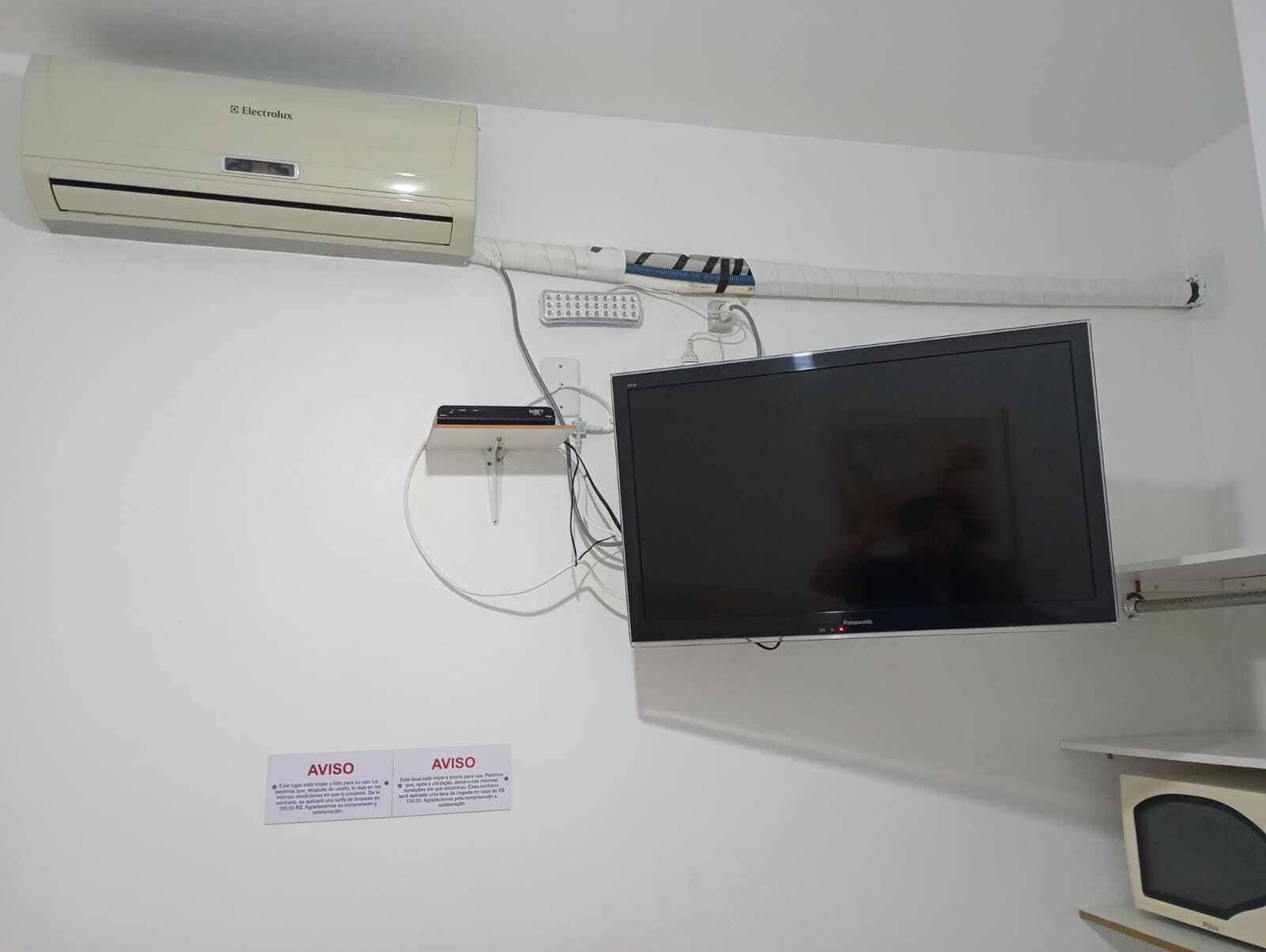 Une pièce équipée d’un téléviseur à écran plat fixé au mur, d’un appareil de climatisation et d’un dispositif médical également fixé au mur.