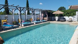 A swimming pool with lounge chairs and a pergola structure. - Cabane de Gardian unique in Petite Camargue Total disconnection unusual accommodation (Vestric et candiac)
