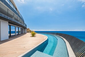 A modern pool area with a wooden deck and a view of the ocean. - Atlantic Gem by Homie (Camara de Lobos)