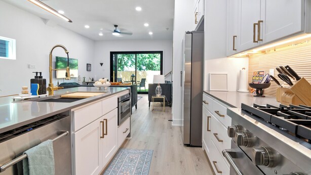 A modern kitchen with stainless steel appliances, white cabinetry, and a central island. - Modern 3BD/2.5 B in The heart Houston minutes from Downtown /Heights (Houston)