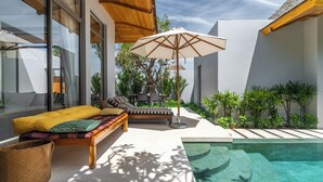 A modern outdoor living area with a pool, a wooden bench with cushions, and an umbrella. - Anchan Flora By Villacarte (Thep Krasattri)