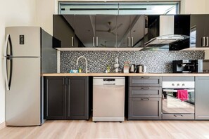 Standaard villa | Privékeuken | Een koelkast met diepvriezer, een microgolfoven, een kookplaat