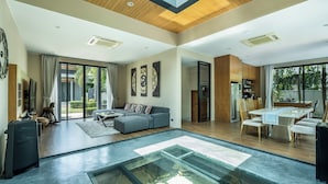 Un vaste espace de vie comprenant un aquarium en verre, une table à manger et un coin salon confortable.