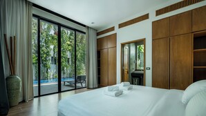 Une chambre d’hôtel moderne dotée d’un grand lit, d’une armoire en bois et d’une porte-fenêtre coulissante donnant sur un espace piscine.