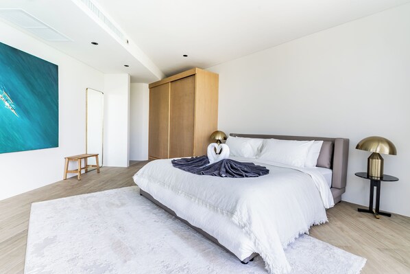 Un dormitorio moderno con una cama grande, un armario de madera y una lámpara de pie.